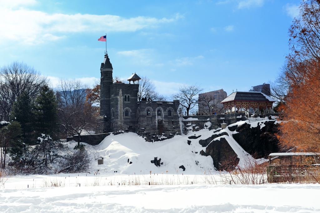 Belvedere Castle on its rocky outcrop in Central Park, New York, with snow on the ground and a blue winter sky