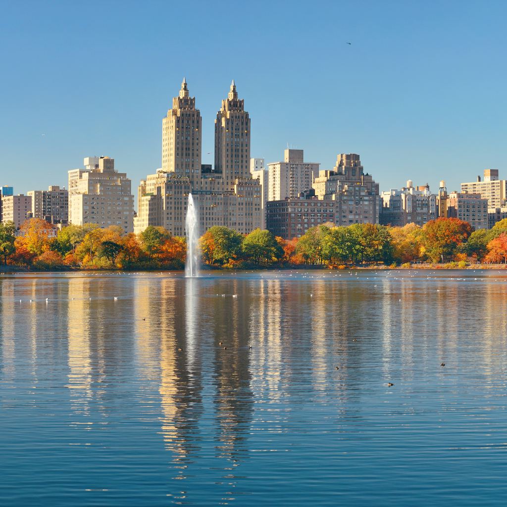 The Reservoir in Central Park with its fountain, autumn trees on the far shore and the twin towers of the Eldorado on Central Park West reflected in the water