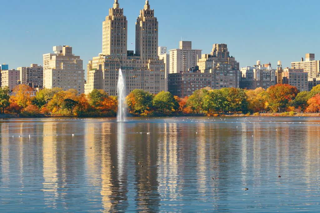 The Reservoir in Central Park with its fountain, autumn trees on the far shore and the twin towers of the Eldorado on Central Park West reflected in the water