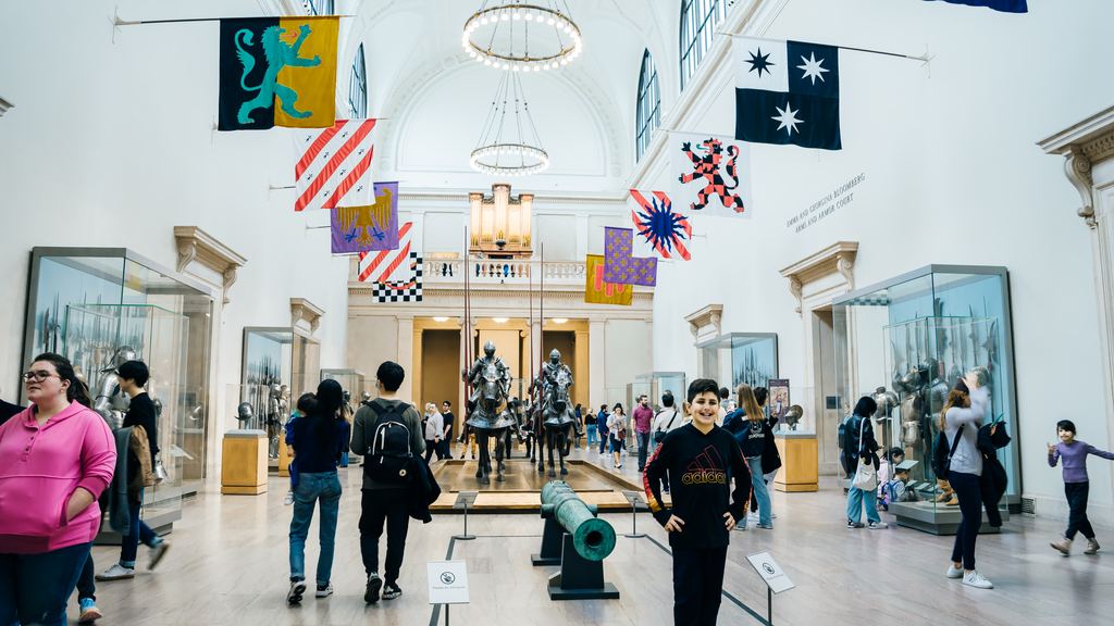 Heraldic banners hanging above mounted armour in the Arms and Armor court of the Metropolitan Museum of Art