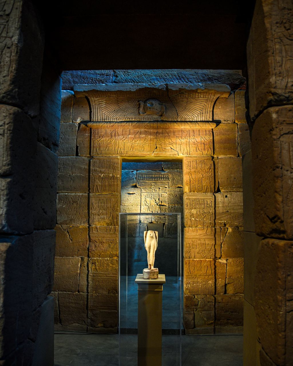 Looking through the carved sandstone gateway of the Temple of Dendur at the Metropolitan Museum into the lit inner sanctuary