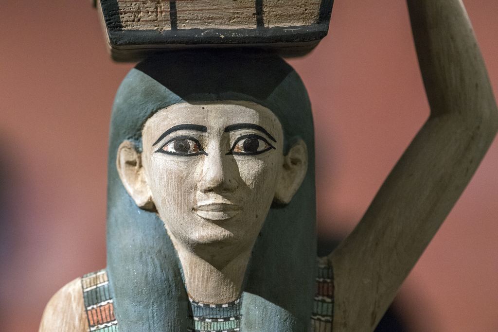 A painted wooden ancient Egyptian statuette of an offering bearer carrying a basket on her head, Metropolitan Museum, New York