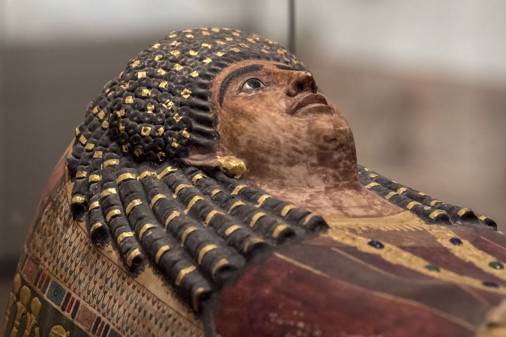 The gilded face and gold-studded wig of an ancient Egyptian coffin in the Egyptian galleries of the Metropolitan Museum