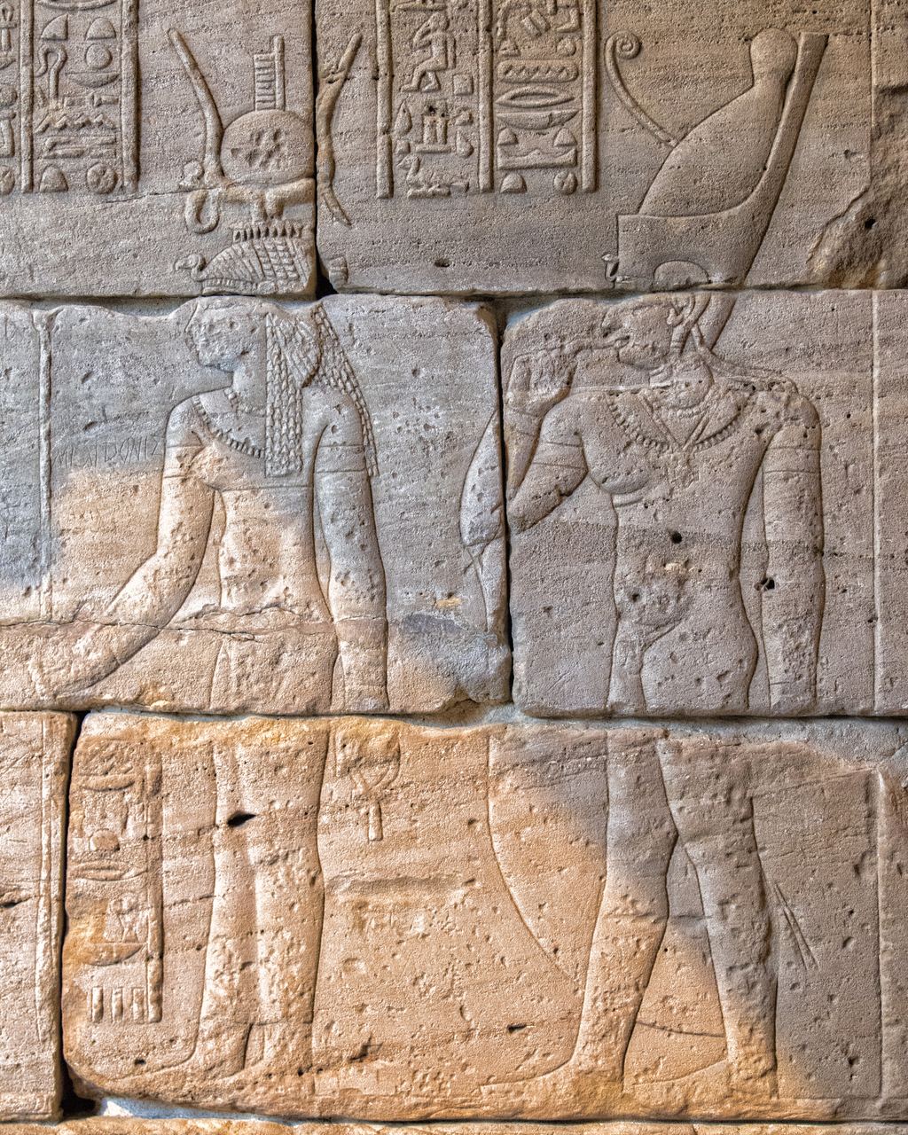 Detail of worn hieroglyphs and a carved figure on a sandstone wall of the Temple of Dendur at the Metropolitan Museum
