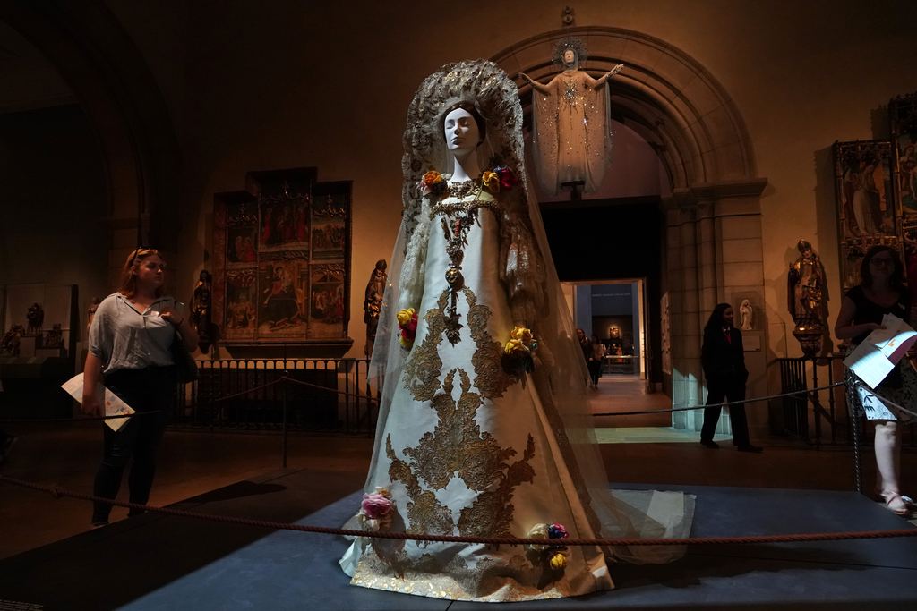 Visitors in a medieval gallery of the Metropolitan Museum of Art with gilded altarpieces on the walls, New York, 2018