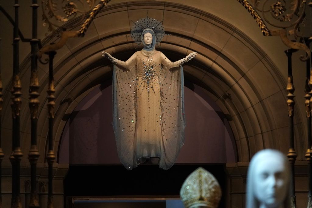A jewelled ceremonial cape displayed under a stone arch in a medieval gallery of the Metropolitan Museum, 2018