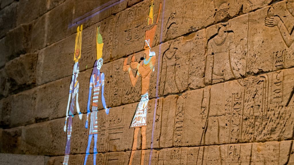 A carved wall of the Temple of Dendur at the Metropolitan Museum with its figures coloured by projected light, 2017