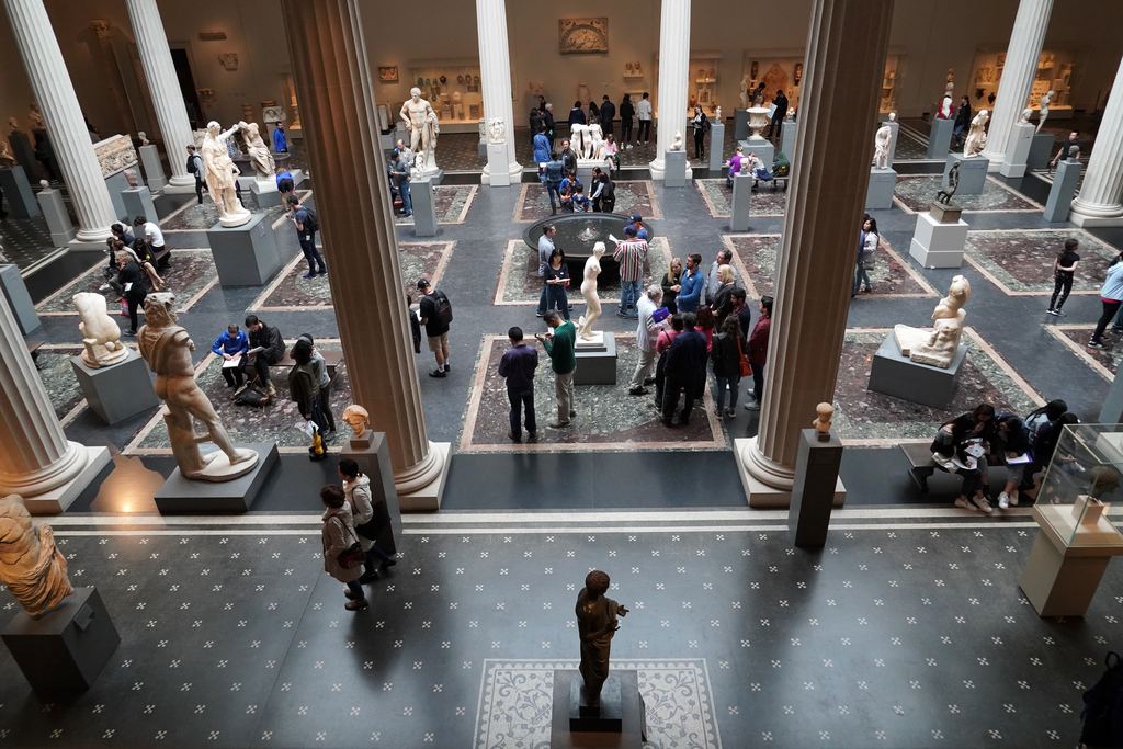 Visitors crossing the Roman sculpture court of the Metropolitan Museum of Art in New York, seen from above between the columns